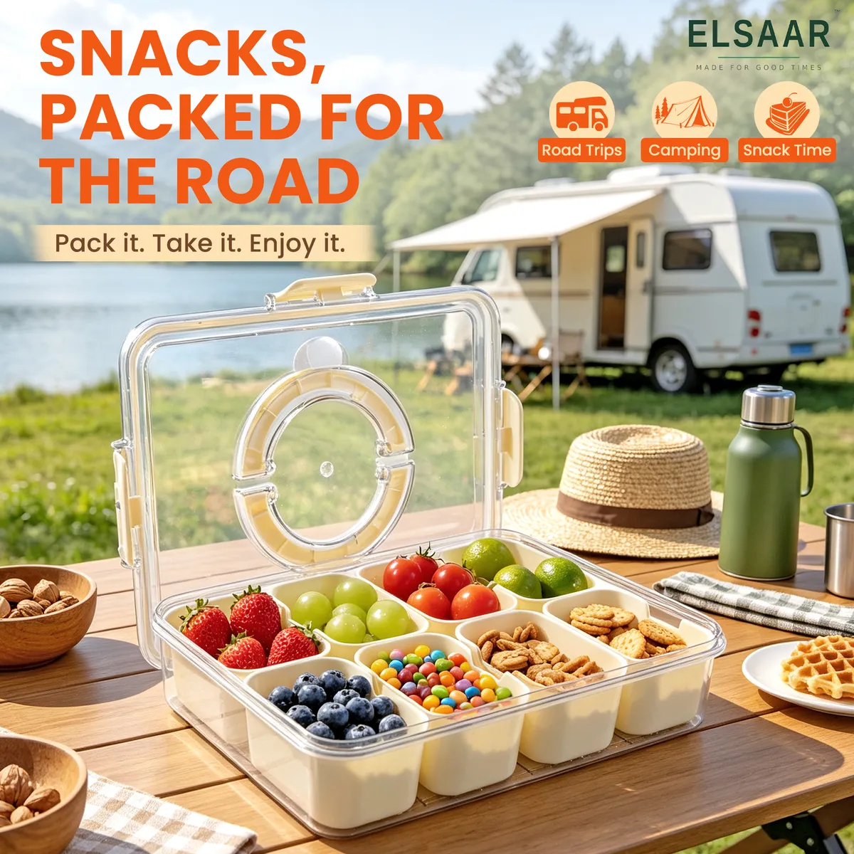 Snackle Box en una mesa de camping junto a un lago y una casa rodante